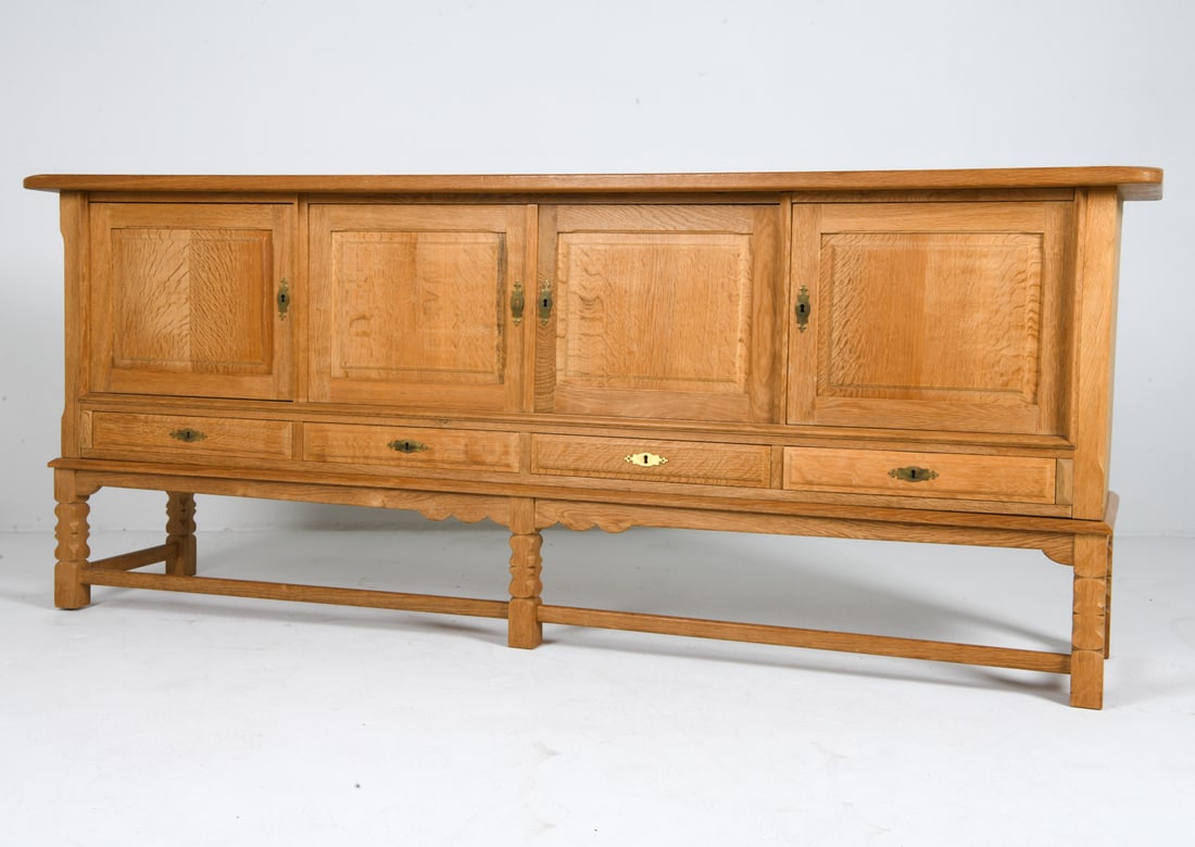 STILMOBLER DANISH OAK SIDEBOARD C. 1970S: Key included. Carved decoration to cabinet doors. Adjustable shelves. Tagged on the back. Denmark, circa 1970s. Dimensions: H 36" x W 89" x D 20". Condition: Wear consistent with age and use including