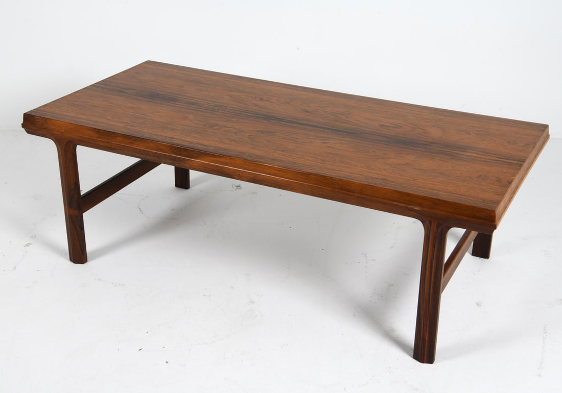 JOHANNES ANDERSEN ROSEWOOD COFFEE TABLE C. 1960S: Rosewood coffee table by Johannes Anderson. Apparently unmarked. Denmark, circa 1960s. Dimensions: H 20" x W 59" x D 27.5". Condition: Wear consistent with age and use, including scratches and rubs.