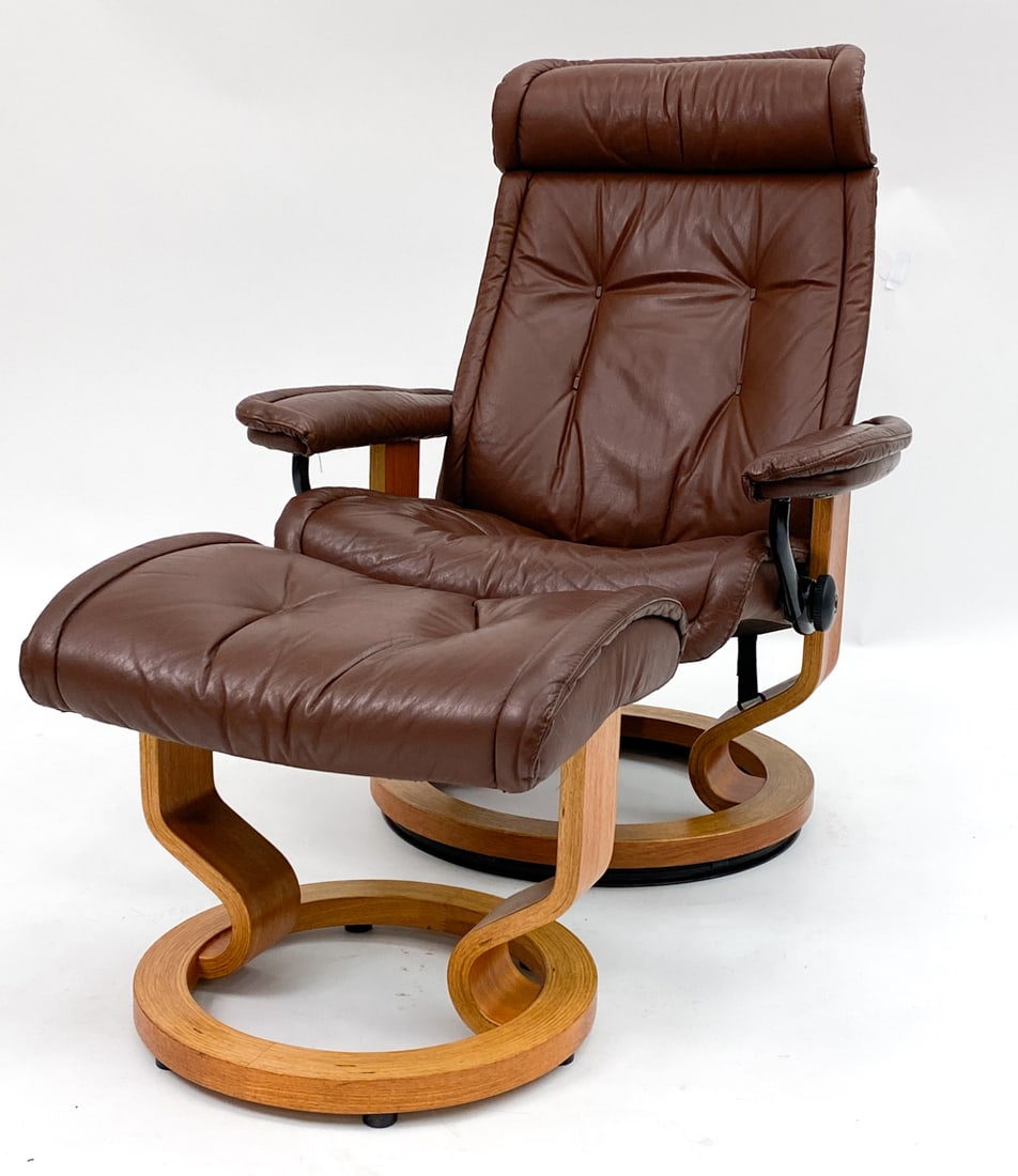 EKORNES 'STRESSLESS' LOUNGE CHAIR & OTTOMAN: Stressless leather and beech bentwood reclining lounge chair with matching ottoman. Tagged under the headrest. Dimensions: H 38" x W 39.5" x D 27" x SH 15.5" Condition: Very minor surface marks, in gr