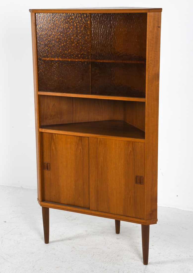 DANISH TEAK & GLASS CORNER CABINET C. 1960S: Teak corner cabinet with sliding amber glass doors to top. Adjustable shelves. Denmark, circa 1960s. Dimensions: H 56.5" x W 32.5" x D 18.5". Condition: Minor scuffs and rubs. Wear consistent with age