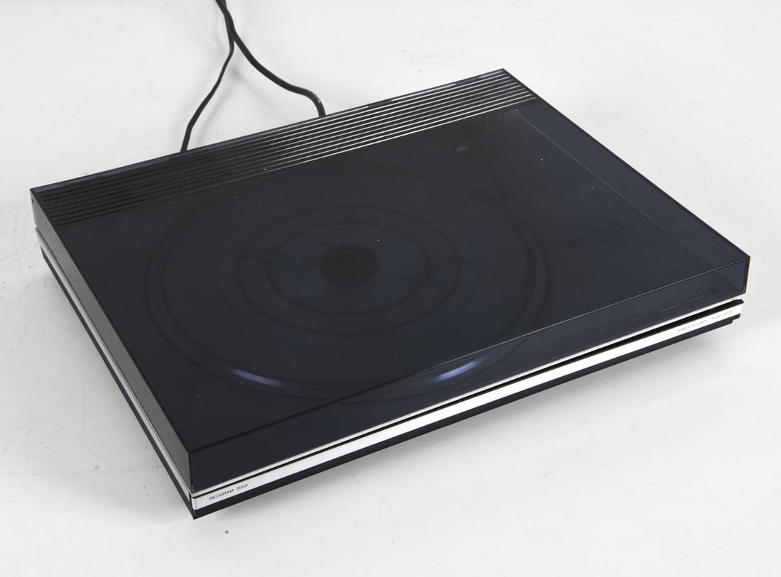 BANG & OLUFSEN BEOGRAM 2000 TURNTABLE C. 1970S: Designed by Jacob Jensen. Fully automatic belt driven turntable with a custom B&O SP14 cartridge. Denmark, circa 1970s. Dimensions: H 3" x W 16.75" x D 13". Condition: Wiring untested. Paint to cord.