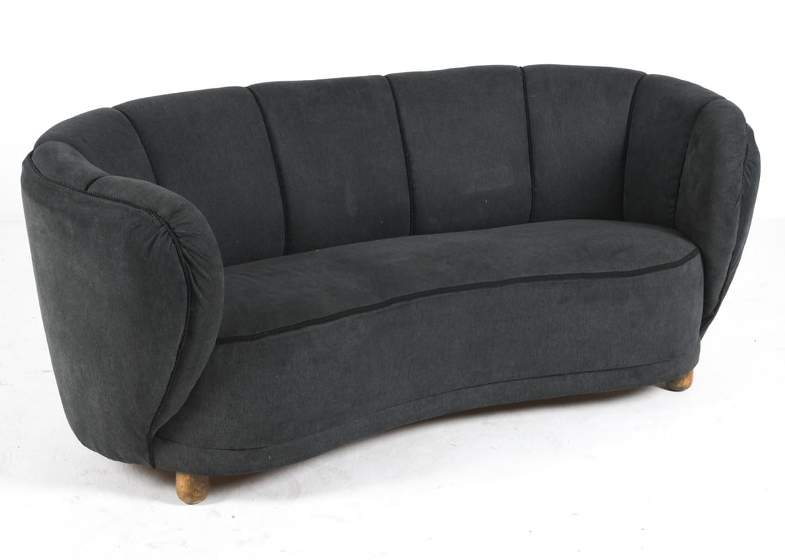 DANISH BANANA SOFA C. 1950S: Banana sofa in navy tone fabric upholstery, channel back. Beech feet. Denmark, circa 1950s. Dimensions: H 26.25" x W 66" x D 31.5" x Sh 15" Condition: Wear consistent with age and use. Scuffs and rubs