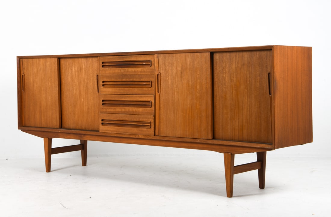 JENSEN & HERNING DANISH TEAK SIDEBOARD C. 1970S: Sliding cabinet doors and drawers to center with inset drawer pulls. Denmark, circa 1970s. Dimensions: H 33.5" x W 87.5" x D 16.5". Condition: Overall presents well, some fading to top. Wear consisten
