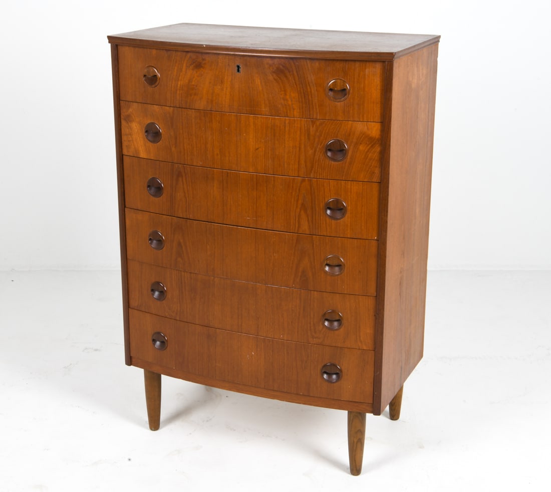 KAI KRISTIANSEN TEAK CHEST OF DRAWERS C. 1960S: Key included. Bow front chest of drawers with molded inset drawer pulls. Denmark, circa 1960s. Dimensions: H 44.5" x W 30.5" x D 17.25". Condition: Faint water rings to top. Wear consistent with age a