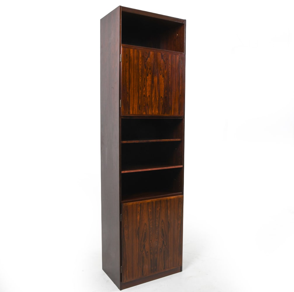 OMANN JUN SCAN-FLEX DANISH ROSEWOOD BOOKCASE 1960S: Tall rosewood bookcase cabinet with doors. Adjustable shelves. Tagged to back. Denmark, circa 1960s. Dimensions: H 84" x W 23.25" x D 16.25". Condition: Minor scuffs. Wear consistent with age and use.