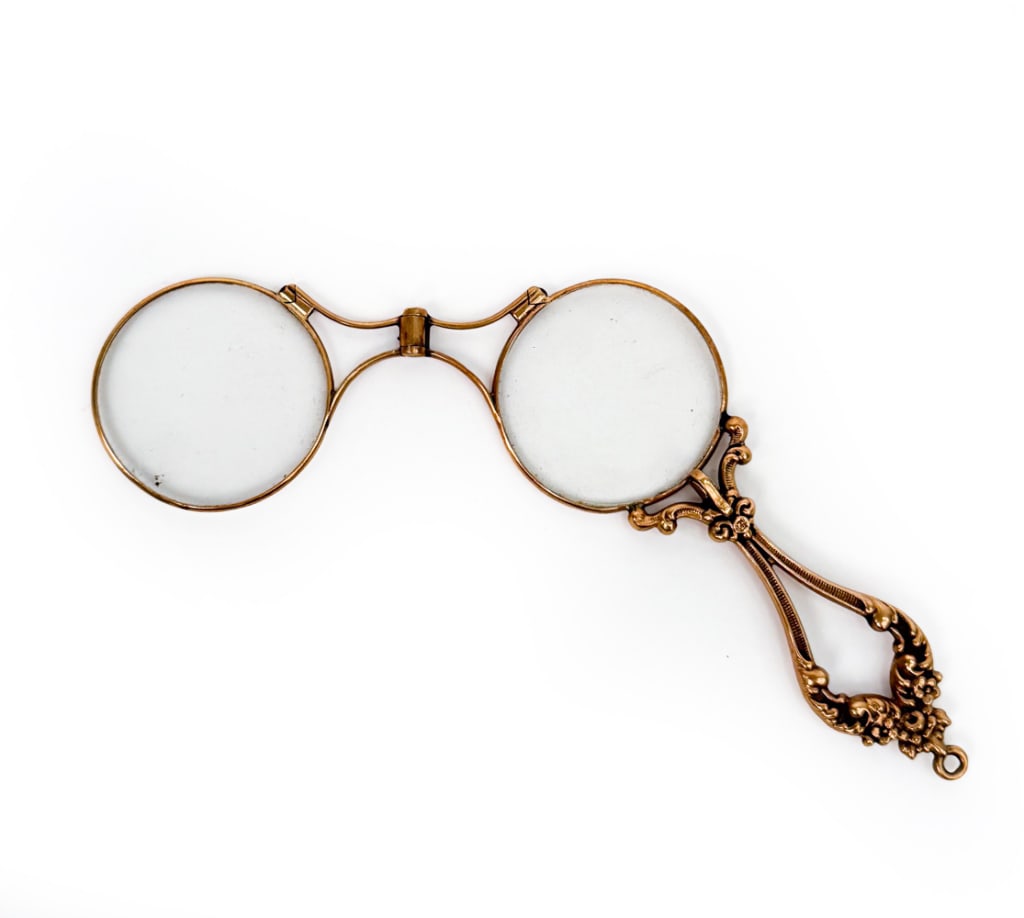 ANTIQUE ART NOUVEAU 14K LORGNETTE OPERA GLASSES: 14K yellow gold rare hinged double lorgnette opera glasses featuring elaborate floral detailing at handle. Marked 14K on handle. Dimensions: H 4" x W 1.25" Condition: Natural patina, small scallop chi