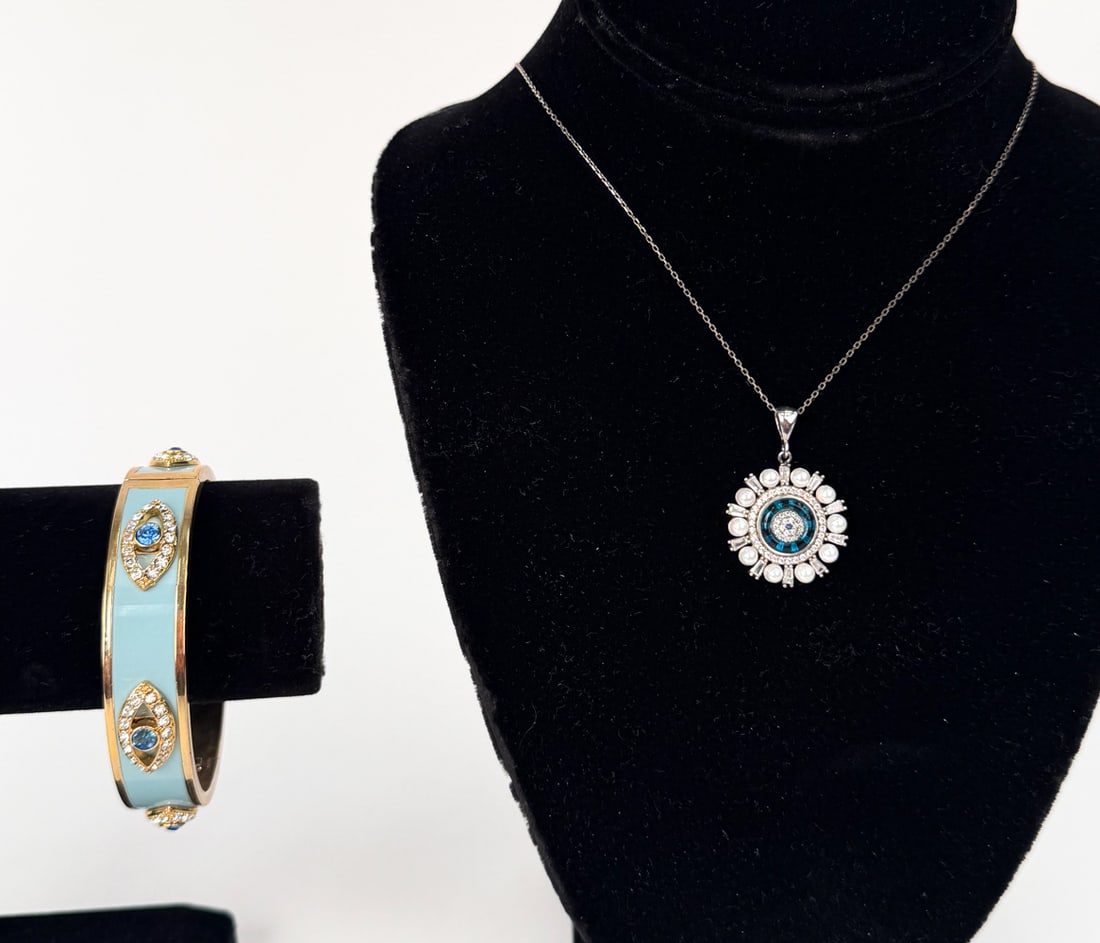 EVIL EYE COSTUME JEWELRY GROUPING: Grouping includes a gold-tone enamel clamper bracelet with crystal accents, G marking on interior. Also includes a sterling chain necklace with a small blue spinel gem in the center of the pendant and