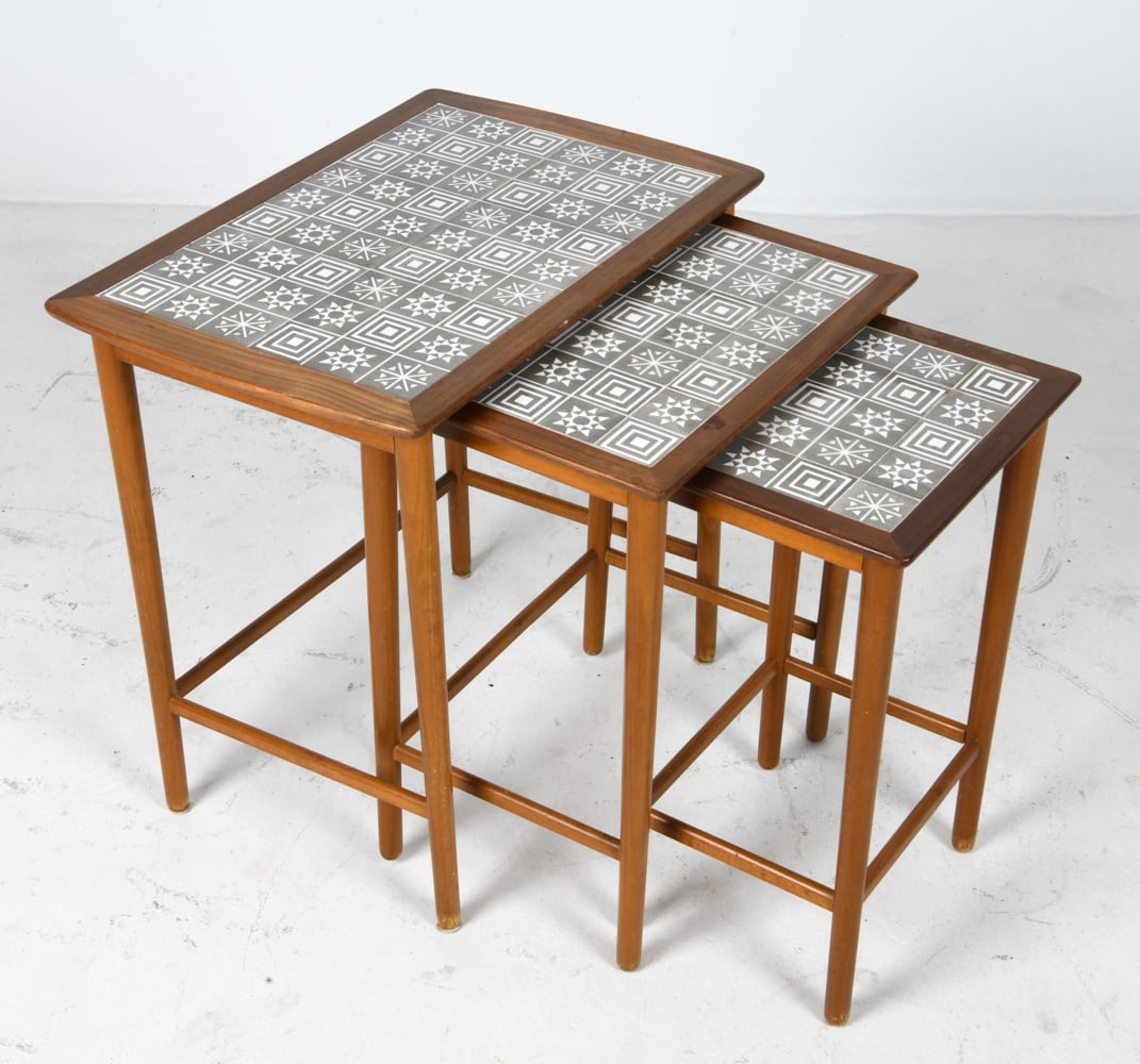 DANISH TEAK & TILE NESTING TABLES C. 1970S: Set of (3) walnut nesting tables with ceramic tiles inlaid to top. Denmark, circa 1970s. Dimensions: Largest H 21" x W 21.5" x D 14.5". Condition: Minor scuffs to wood, wear consistent with age and us