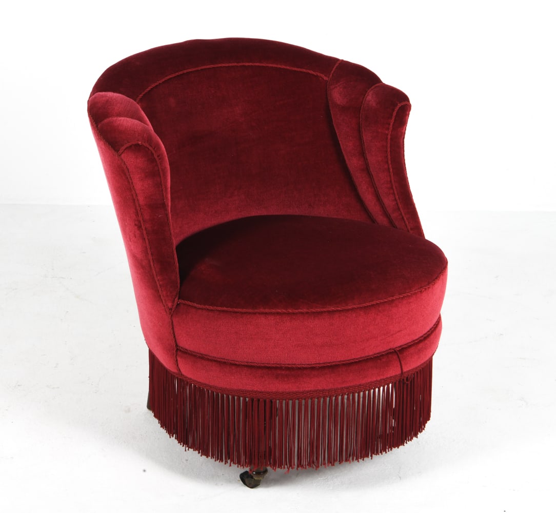 MID-CENTURY MOHAIR SKIRTED LOUNGE CHAIR C. 1950S: Lounge chair with red mohair upholstery and channel back. Denmark, circa 1950s. Dimensions: H 30" x W 29" x D 28" x Sh 17". Conditions: Wear consistent with age and use. Few rubs and dings to legs.