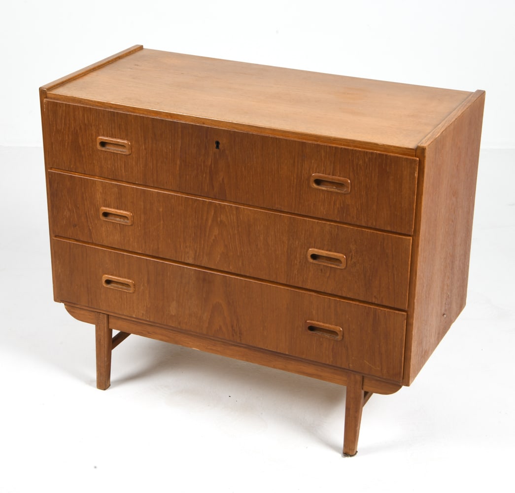SWEDISH TEAK CHEST OF DRAWERS C. 1960S: Teak dresser features three drawers. Key included. Sweden, circa 1960s. Dimensions: H 28" x W 33.5" x D 15.75" Condition: Wear consistent with age and use including scratches and rubs, minor sun-fadin