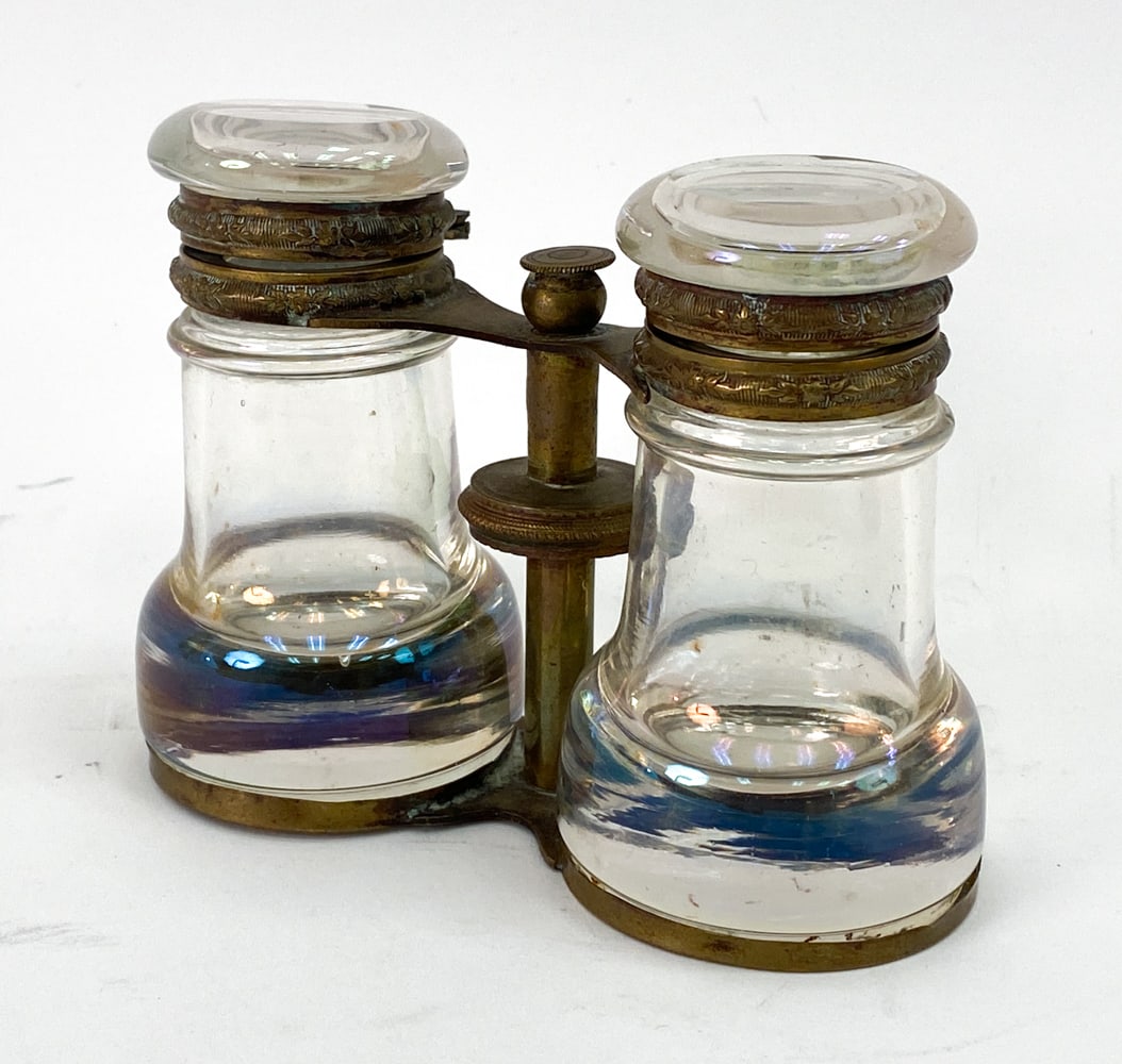 19TH C. FRENCH OPERA GLASSES PERFUME BOTTLES: Antique 19th century French iridescent glass and brass perfume bottles in opera glasses form. Apparently unmarked. Dimensions: H 3.75" x W 4.5" x D 2" Condition: Oxidation to brass. Light surface mark