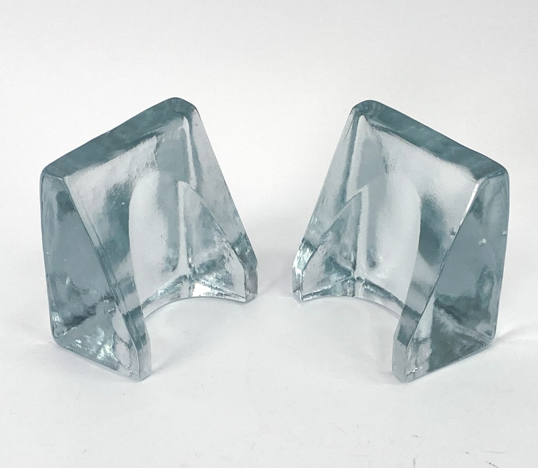 PAIR OF WAYNE HUSTED "BLENKO" SOLID GLASS BOOKENDS: Set of two bookends by Wayne Husted, "Blenko" model. Apparently unmarked. Dimensions: H 5" x W 5" x D 3.5" Condition: No issues to note.
