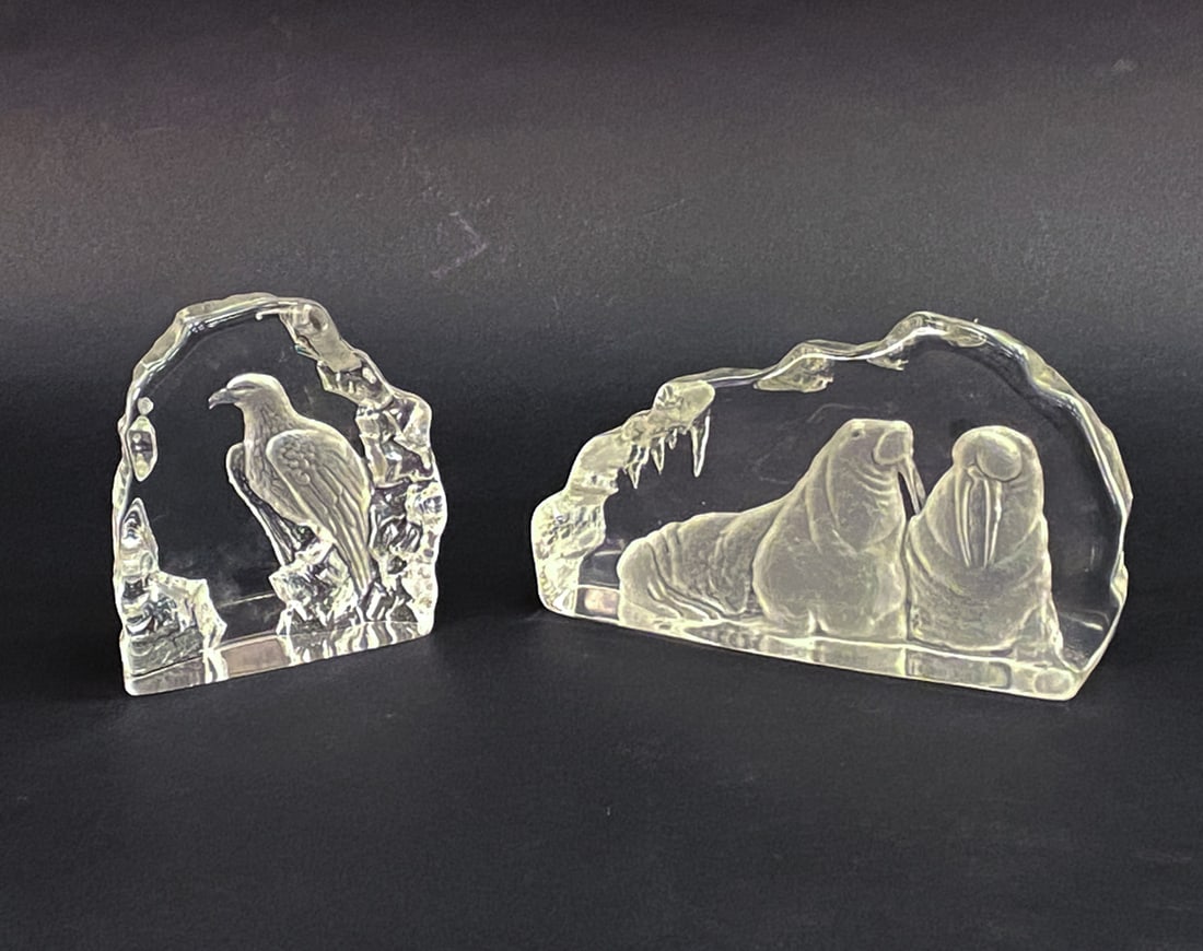 MATS JONASSON CRYSTAL PAPERWEIGHT SCULPTURES: Larger piece depicts a pair of walruses and the other smaller crystal features a bald eagle. Both signed on undersides and numbered. Dimensions: (Larger) H 6.25" x W 10" x D 2" Condition: Couple small