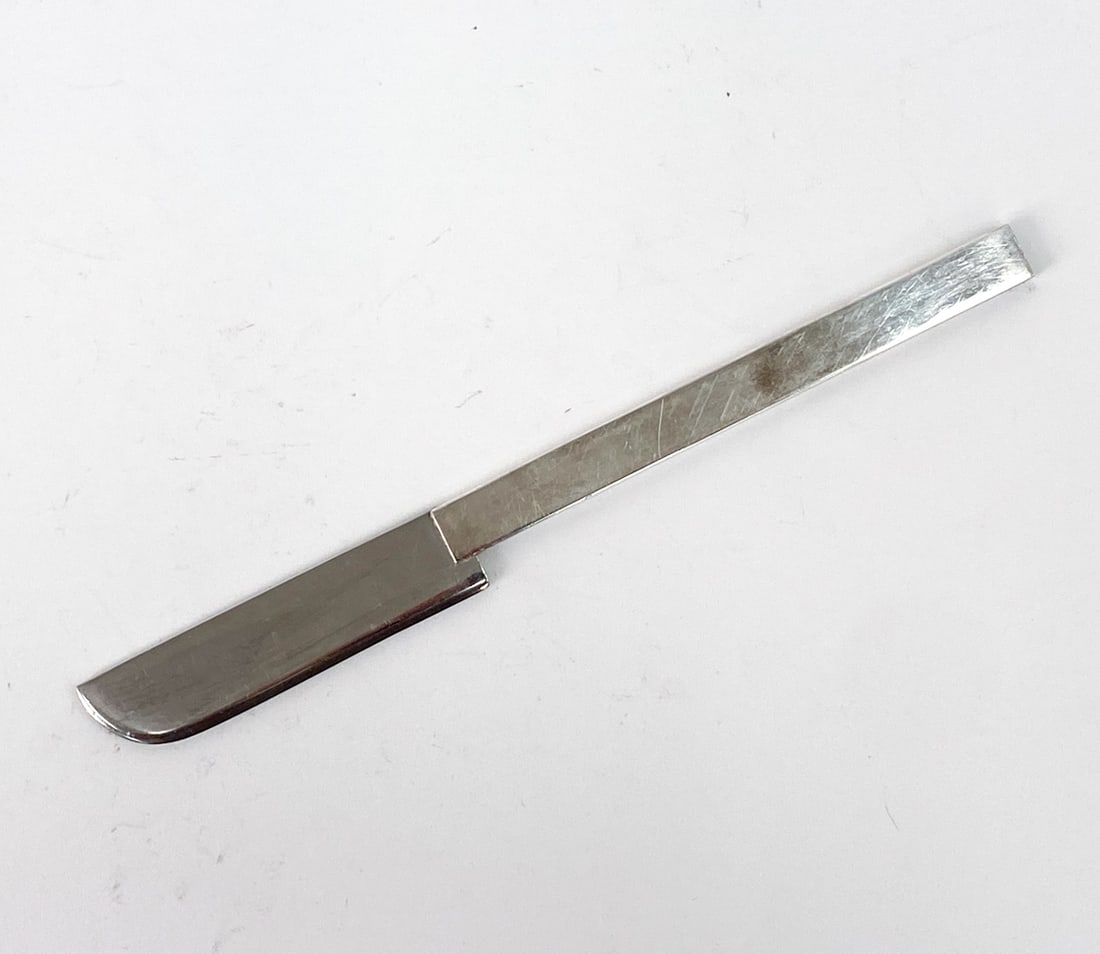 RUSSEL WRIGHT FOR MMA SILVER PLATE KNIFE 1987: Machine Age style silver-plated knife for Metropolitan Museum of Art by Russel Wright. Designed in 1933. Inscribed "MMA 1987 Korea" on the side of handle. Dimensions: H 8" x W 0.75" Condition: Minor s