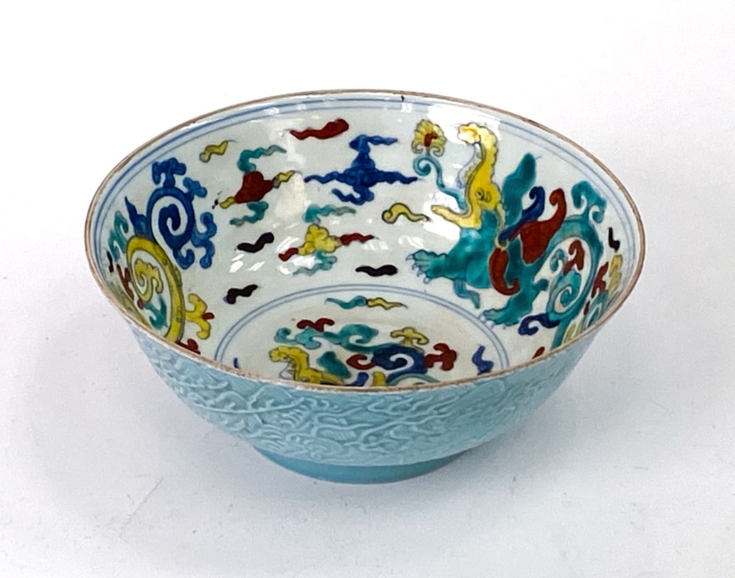 "DOUCAI" MING DYNASTY MOTIF CHINESE PORCELAIN BOWL: Decorated with dragon and cloud motifs. The style is known as "doucai" ware. Marked with Chinese characters to underside. Dimensions: H 3" Dia 7" Condition: Very light rubbing to rim.