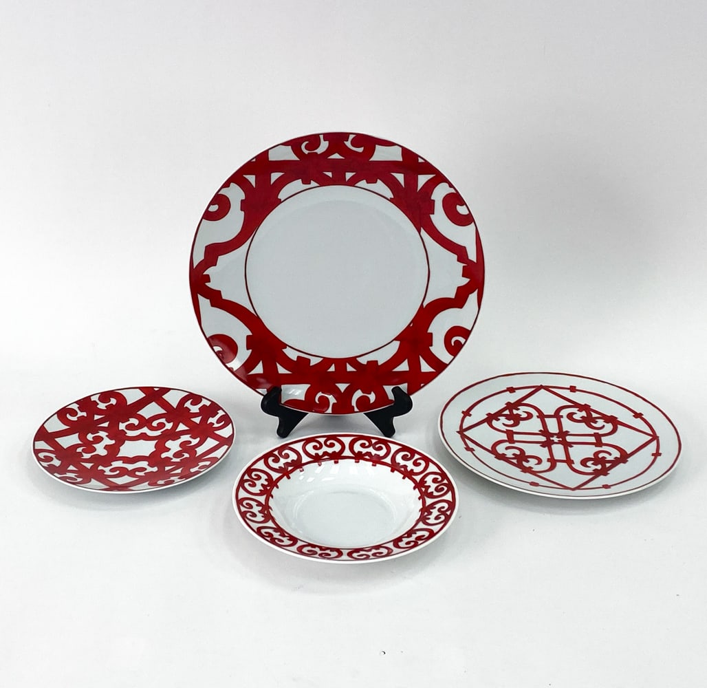 HERMES BALCON DU GUADALQUIVIR PORCELAIN GROUPING: Part of the Hermes Balcon du Guadalquivir dinnerware collection. Inspired by the intricate wrought iron balconies found along the Guadalquivir River in southern Spain. Each plate is marked on undersid