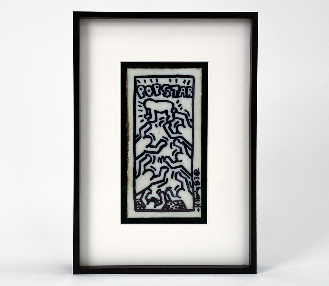 ATTR KEITH HARING (AMERICAN 1958-1990) SUBWAY TILE: Titled "Popstar" with seven figures, 1983, felt-tip marker on glass subway tile. Signed and dated upper left corner. Framed. Dimensions: (Frame) H 10.25" x W 7.25" (Tile) H 6" x W 3" Condition: Small