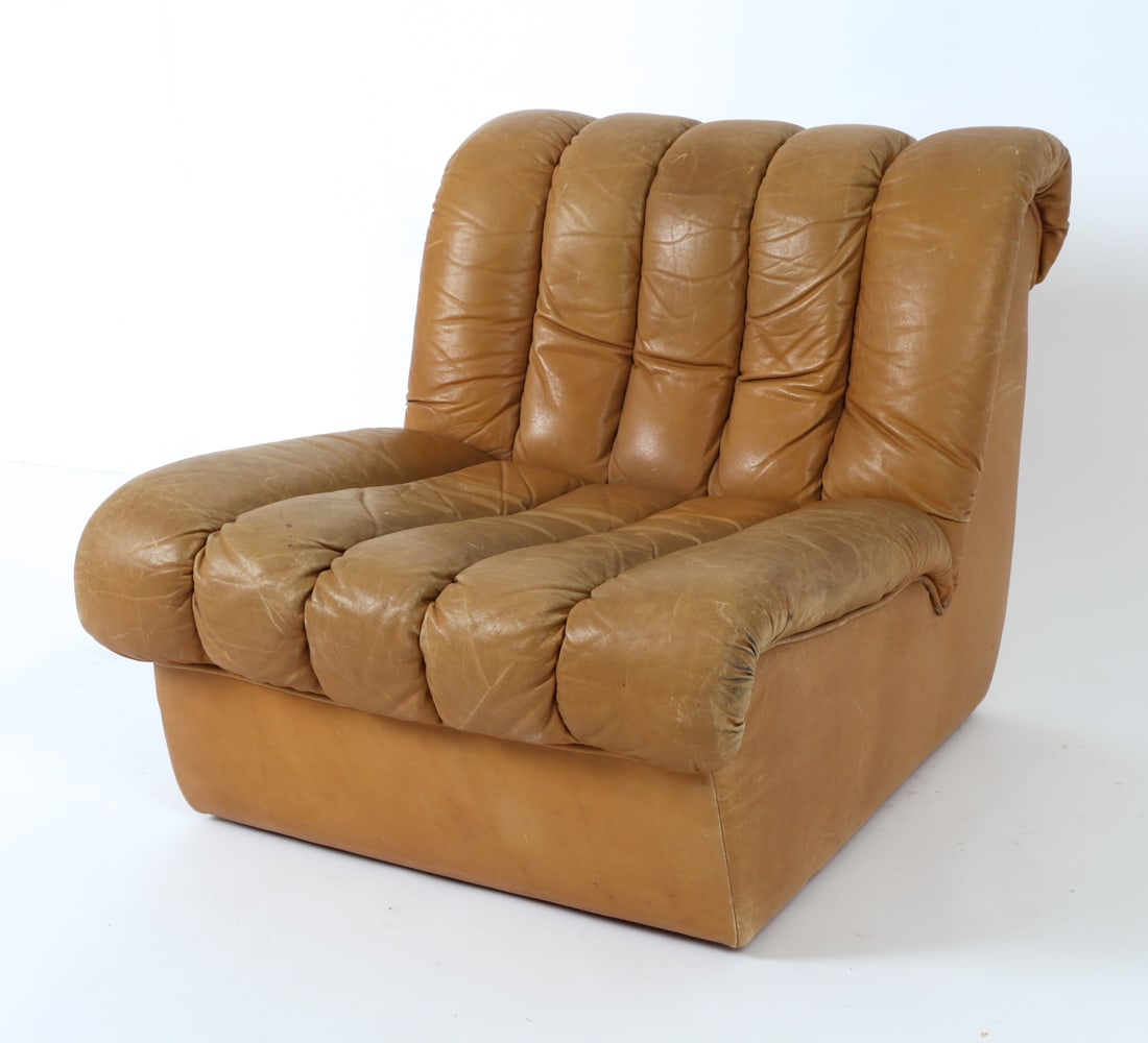 ATTR. DE SEDE DS-85 LEATHER LOUNGE CHAIR C. 1970'S: Beige leather lounge chair. Circa 1970's. Dimensions: H 27" x W 28" x D 29" x SH 14" Condition: Rubbing, creasing, scuffs, light scratches and sun fading, with minor soiling spots. Wear consistent wit