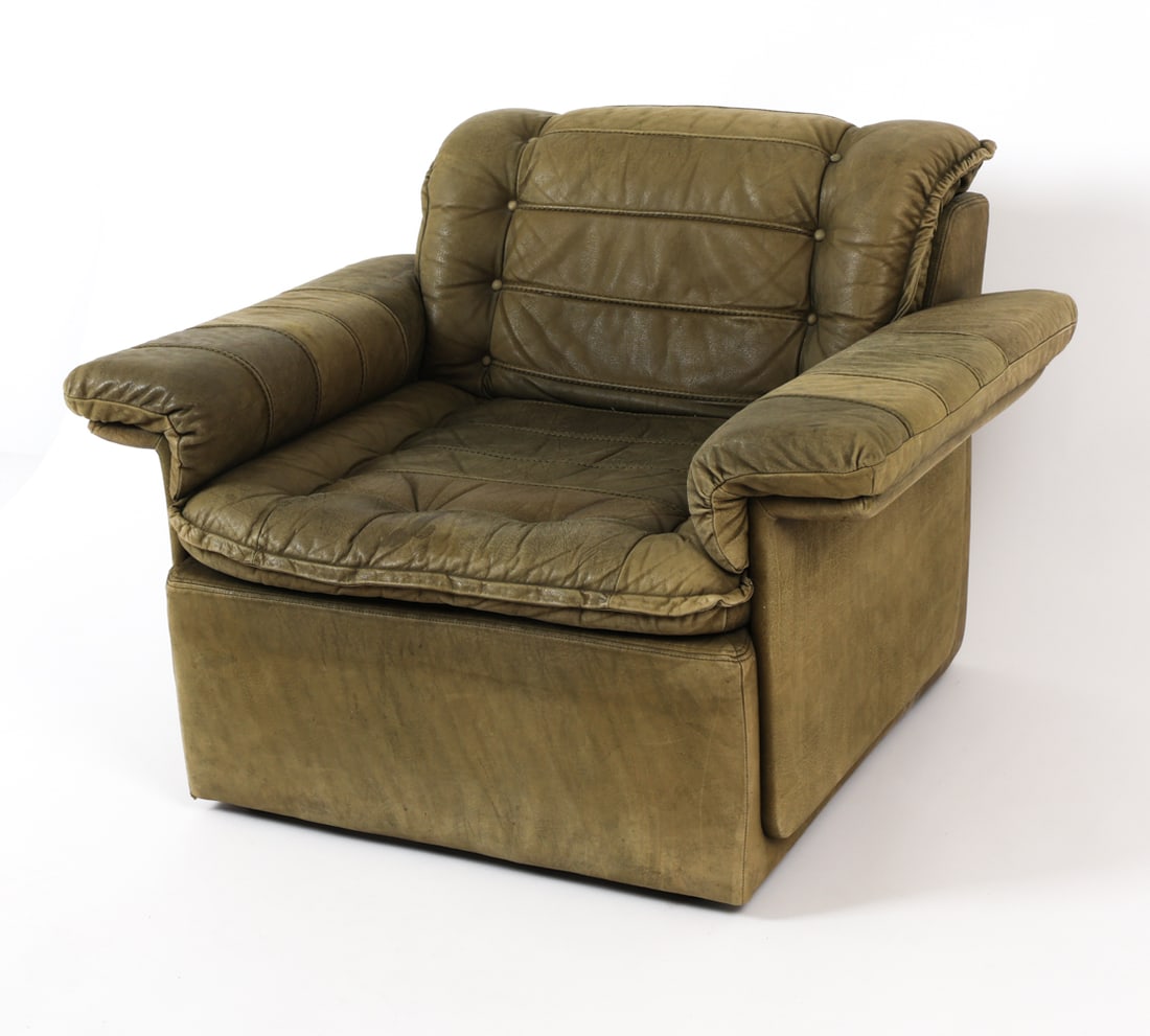 DE SEDE STYLE LEATHER LOUNGE CHAIR CIRCA 1970'S: Tufted green leather lounge chair in the style of De Sede. Circa 1970's. Dimensions: H 29" x W 39" x D 32" x SH 15.5" Condition: Creasing, some discoloration, scuffs, few soiling spots and creasing. P