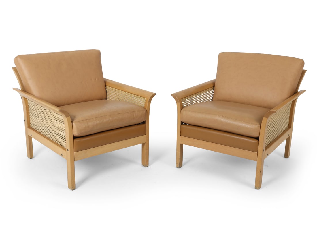 PAIR OF ARNE NORELL BEECH & LEATHER LOUNGE CHAIRS: Two Swedish lounge chairs by Arne Norell, featuring leather cushions, beechwood frame, cane mesh back and sides. Marked underneath the seat cushion. Sweden, circa 1970's. Dimensions: H 31" x W 29" x D
