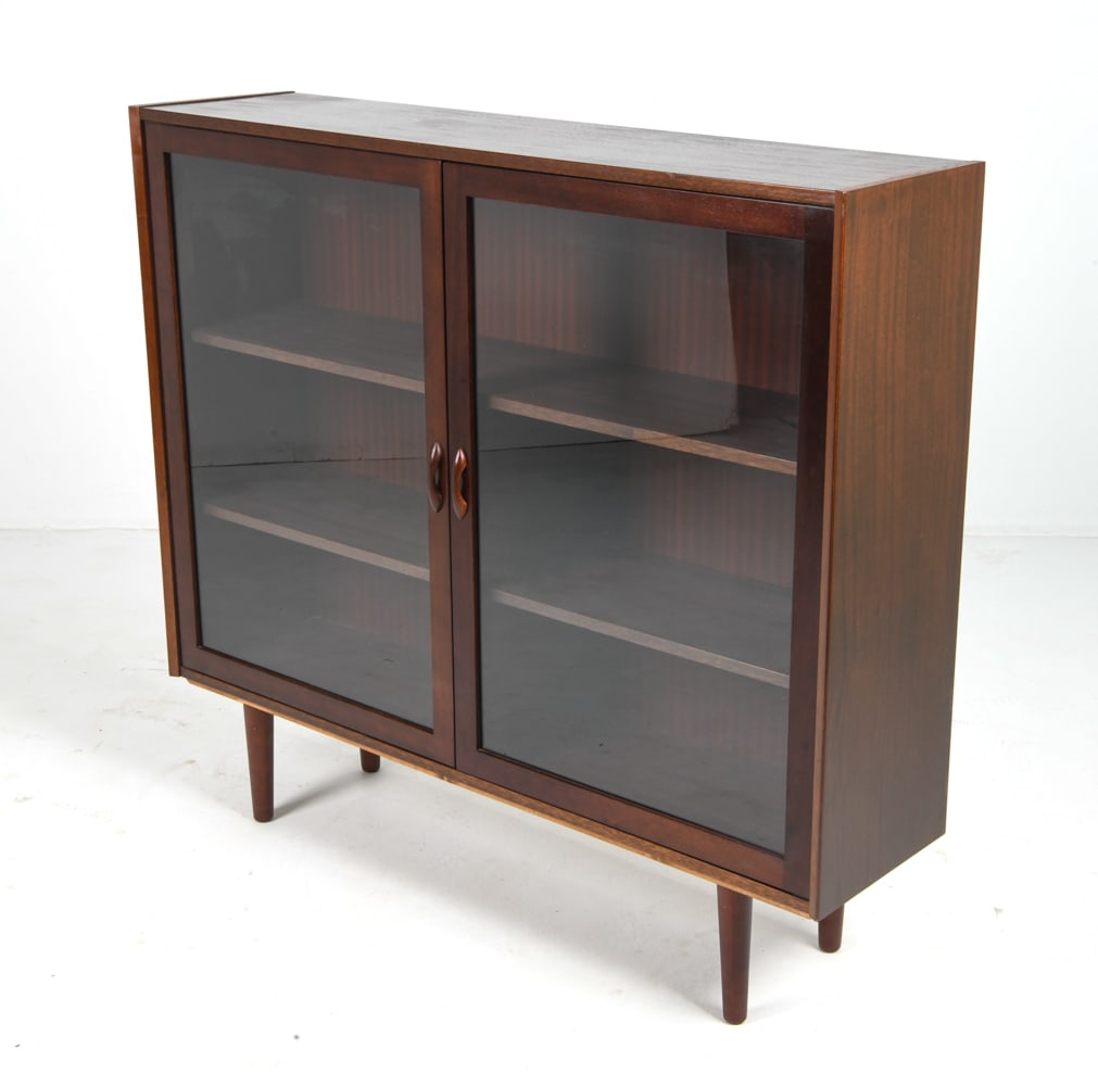 MANNER OF HUNDEVAD DANISH ROSEWOOD BOOKCASE 1960S: Rosewood cabinet with glass cabinet doors. Denmark, circa 1960s. Dimension: H 42.5" x W 47.25" x D 11.75". Conditions: Wear consistent with age and use including faint rubs and scuffs. Tobacco odor in
