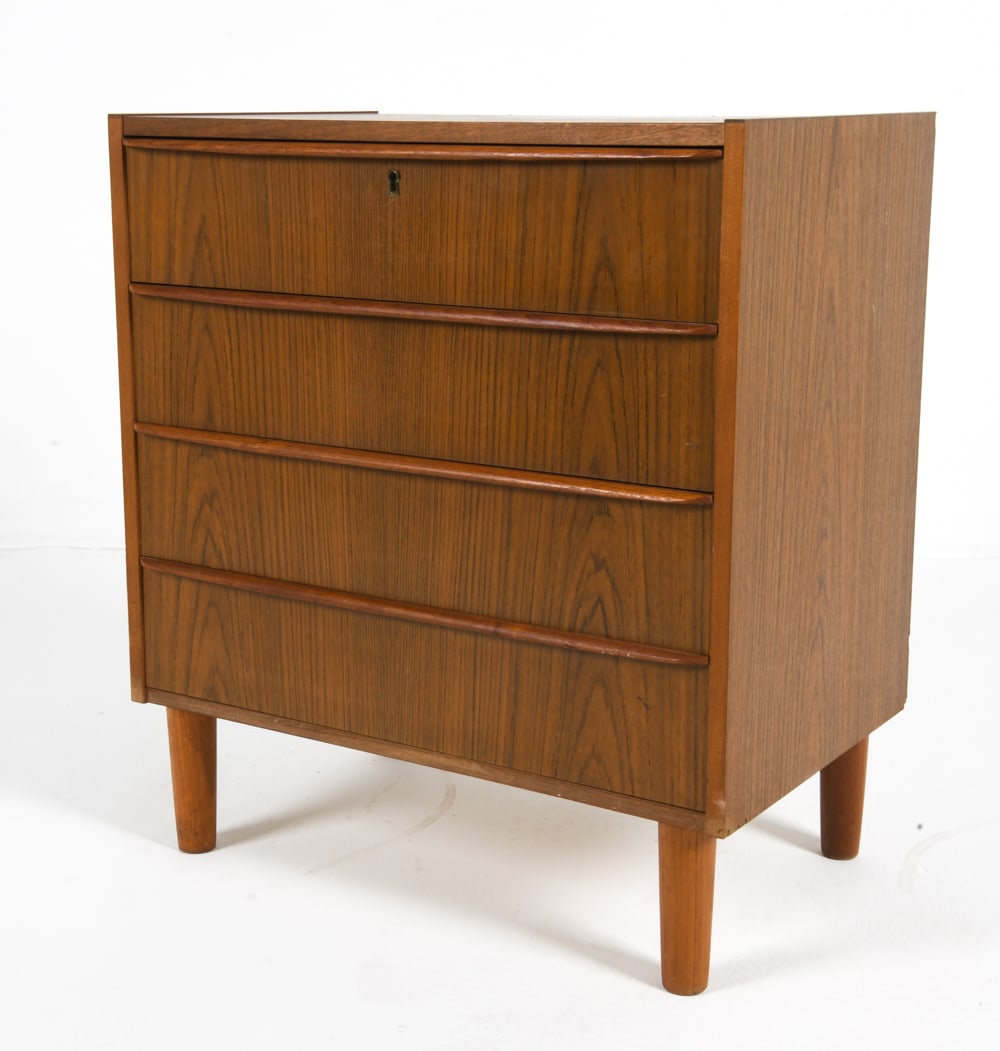 DANISH TEAK CHEST OF DRAWERS C. 1960S: Four drawers with integrated pulls on tapered legs. Denmark, circa 1960s. Dimensions: H 27.25" x W 24.5" x D 15.5". Conditions: No key. Wear consistent with age and use including minor rubs and scuffs