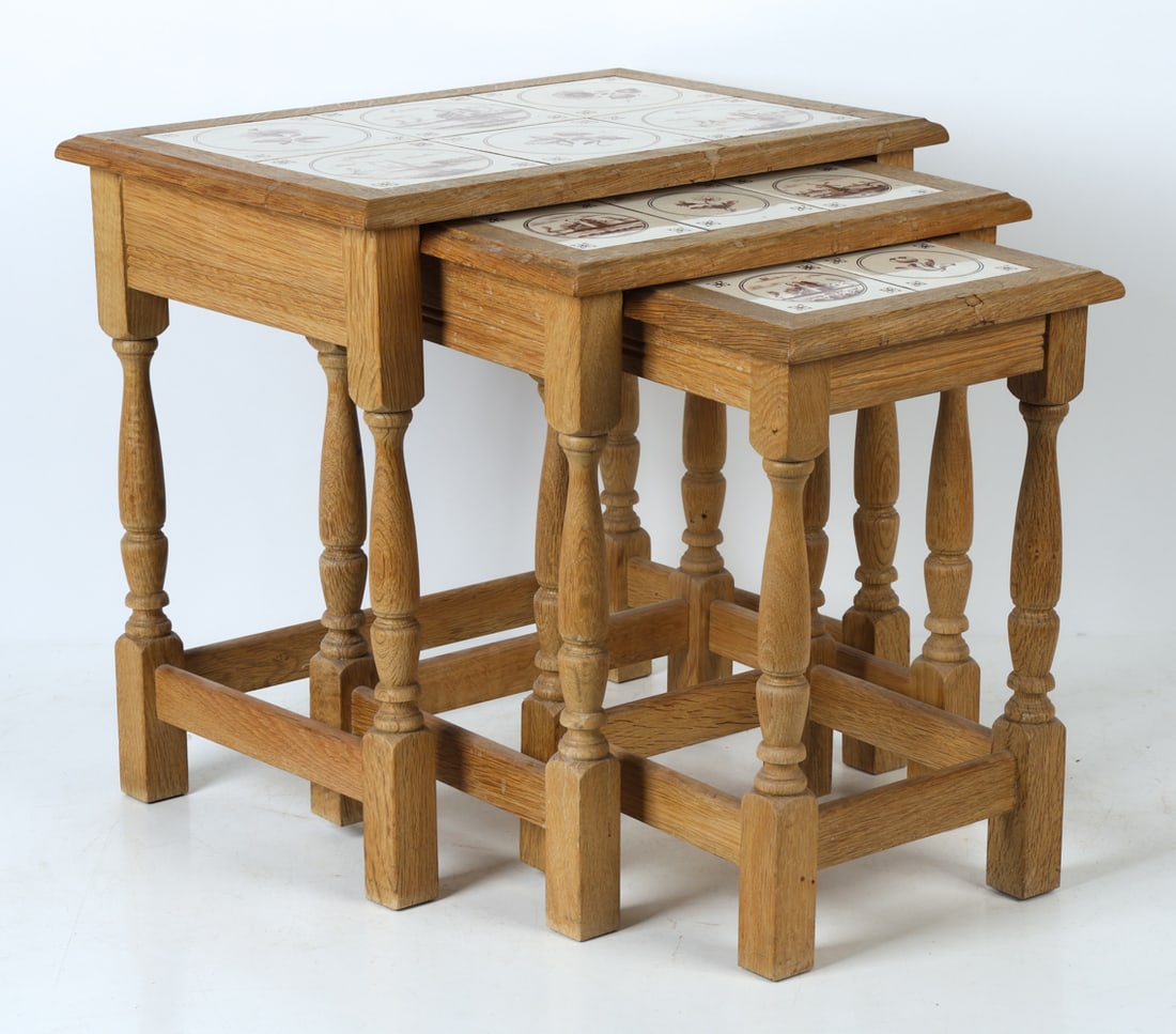 DANISH OAK & CERAMIC TILE NESTING TABLES C. 1970S: Set of (3) oak nesting tables with ceramic tiles inlaid to tops. Danish imagery painted to tiles. Denmark, circa 1970s. Dimensions: H 20" x W 21.25" x D 15.5". Condition: Wear consistent with age and