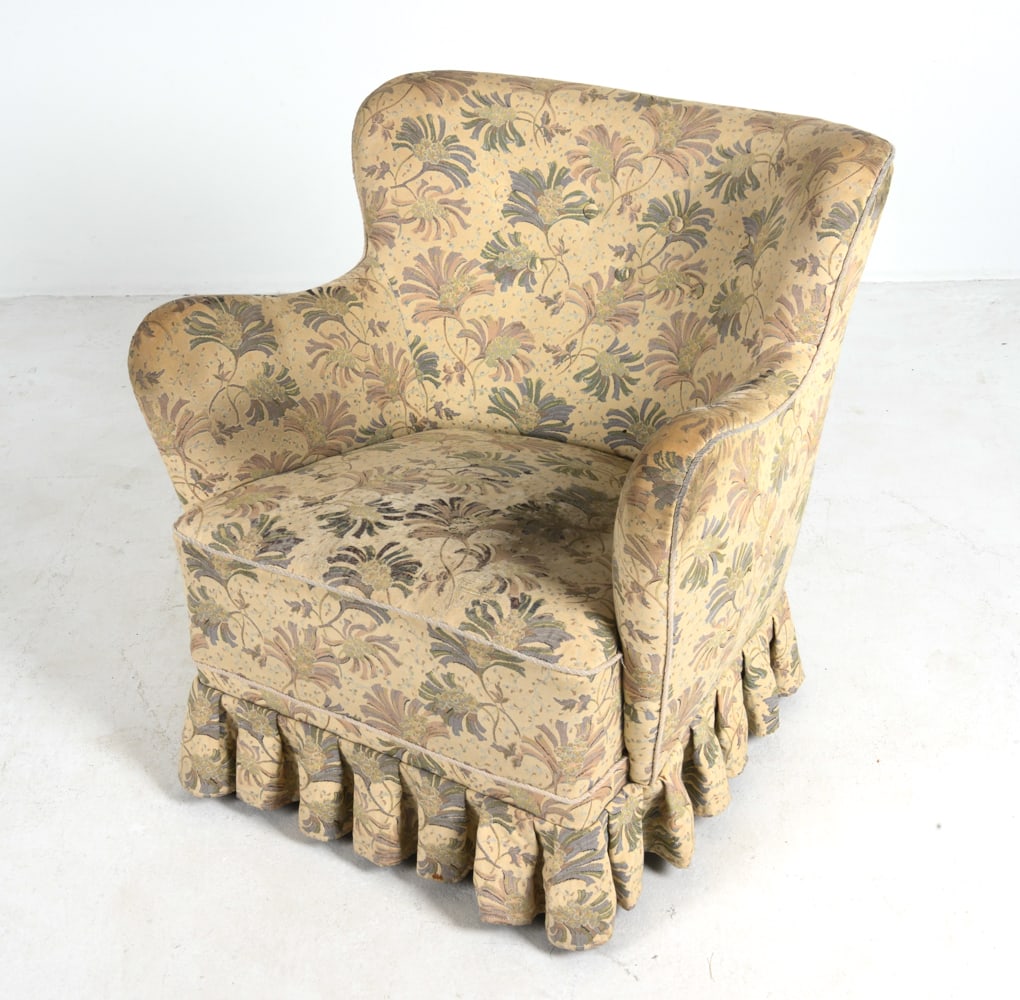 STYLE OF HENNINGSEN DANISH LOUNGE CHAIR C. 1960S: Lounge chair in floral fabric upholstery with skirt. Beech feet. Denmark, circa 1960s. Dimension: H 29.75" x W 28.75" x D 30" x Sh 15.75". Conditions: Wear consistent with age and use, some discolorat