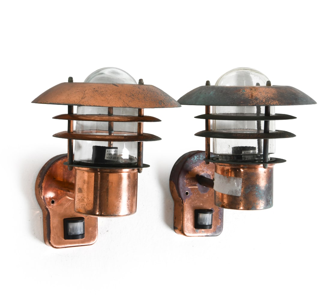PAIR OF NORDLUX COPPER OUTDOOR SCONCES: Pair of copper outdoor sconces with sensors. Denmark, late 20th century. Dimensions: H 11.75" x W 8" x D 10.5". Conditions: Wear consistent with age and use, wiring untested. Scuffs, scratches, and ru