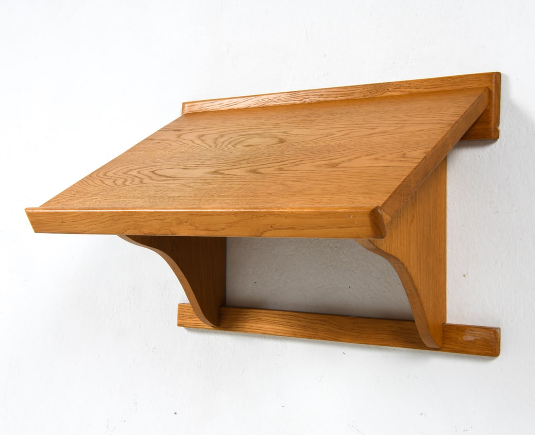 BORGE MOGENSEN STYLE DANISH OAK WALL SHELF C.1970S: Oak wall shelf with a tilted top. Denmark, circa 1970s. Dimensions: H 14" x W 20.5" x D 12.5". Conditions: Wear consistent with age and use. Few faint scratches and rubs.