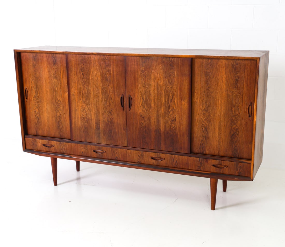 OMANN JUN STYLE DANISH ROSEWOOD SIDEBOARD C. 1960S: Four sliding doors with adjustable shelves and drawers. Denmark, circa 1960's. Dimensions: H 43" x W 73.5" x D 17" Conditions: Wear consistent with age and use including minor dings and rubs, minor lo
