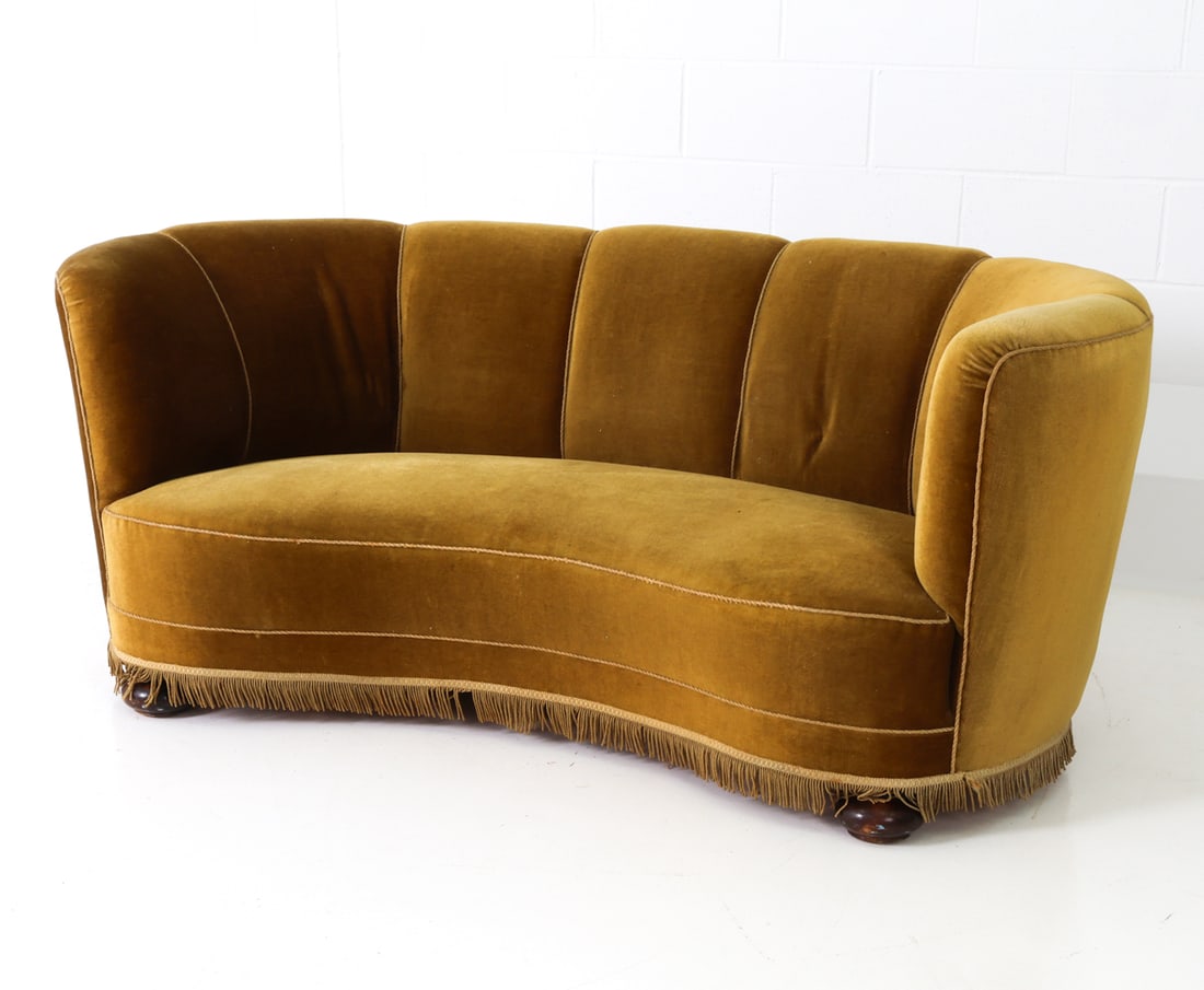 DANISH MOHAIR BANANA SOFA C. 1940S: Danish mohair banana sofa with fringe skirt and round oak legs. Denmark, circa 1940's. Dimensions: H 29" x W 68" x D 30" x SH 16" Condition: Light signs of use and wear consistent with age. Nicks and