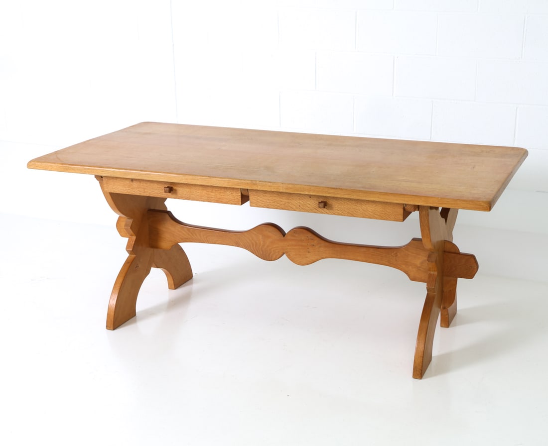 SCANDINAVIAN OAK DINING TABLE WITH STORAGE C.1970S: Oak trestle dining table, featuring two double-sided drawers. Scandinavian, circa 1970's. Dimensions: H 28.5" x W 70.75" x D 33.5" Conditions: Wear consistent with age and use including faint dings an