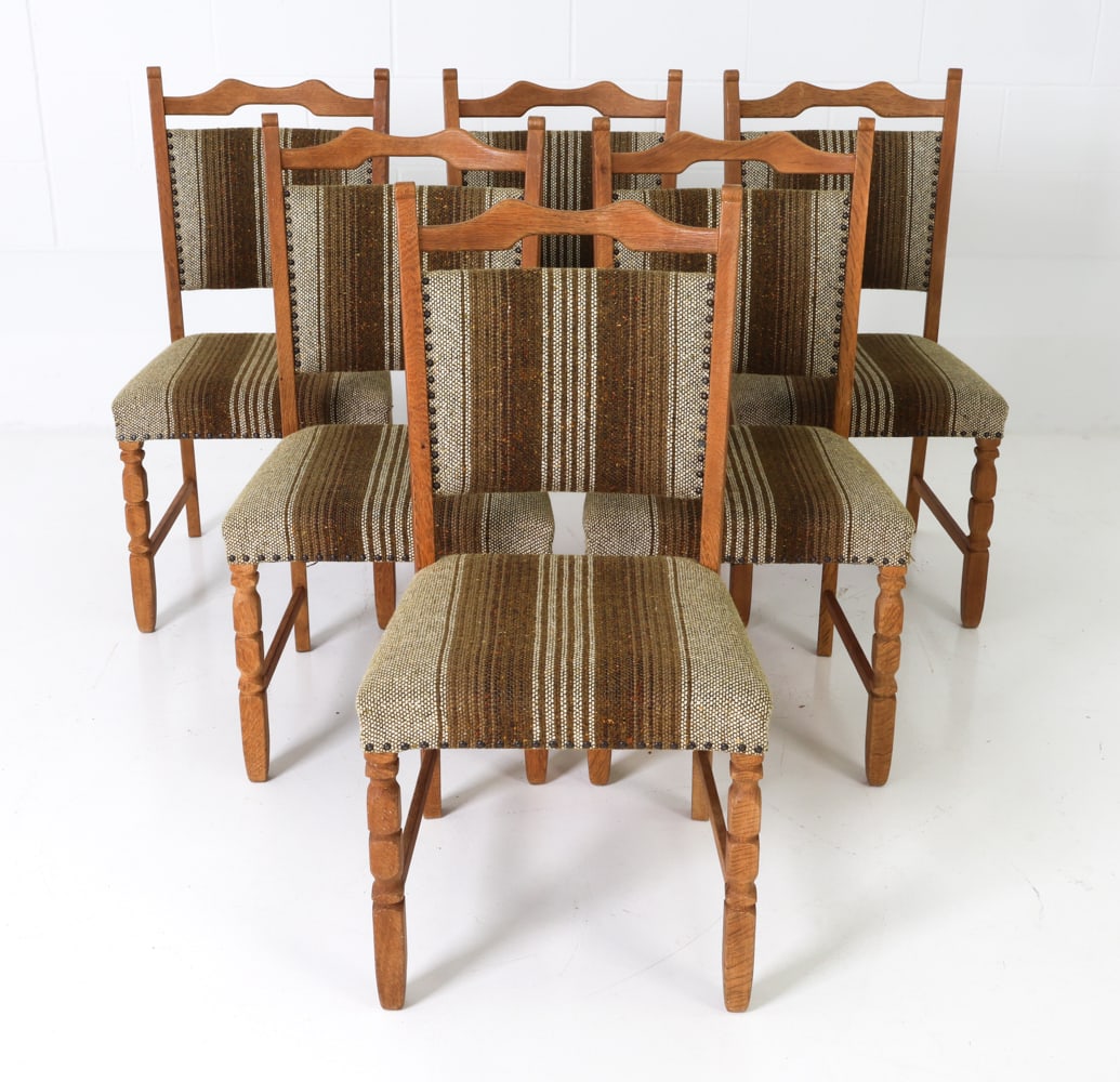(6) ATTR. HENNING KJAERNULF OAK DINING CHAIRS: Grouping of six dining chairs with oak frames and striped upholstery. Denmark, circa 1960s. Dimensions: H 37" x W 18.75" x D 20.5" x SH 18" Condition: Couple loose threads to upholstery where tacks ar