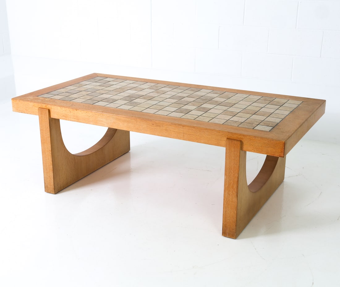 DANISH OAK & CERAMIC TILE COFFEE TABLE C. 1970S: Danish oak coffee table with a patterned ceramic tile top. Denmark, circa 1970's. Dimensions: H 21.75" x W 63.75" x D 32.5" Condition: Very light scuffs and soiling spots to one edge. Wear consistent