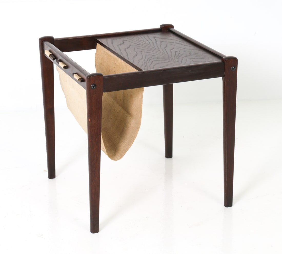 BRDR FURBO DANISH OAK MAGAZINE RACK C. 1960'S: Magazine rack in dark stained oak with fabric sling. Tagged underneath. Denmark, circa 1960's. Dimensions: H 18" x W 18" x D 18" Condition: Few minor scuffs and nicks. One legs is loose, The frame has
