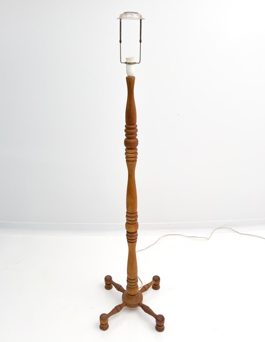 DANISH TURNED OAK FLOOR LAMP: X-form base with turned oak designs. Unmarked. Dimensions: H 62" x Dia 20" Condition: Untested. European plug. Minor stress cracks to wood. Few scuffs and patina to brass. Lacking shade. ES2-180