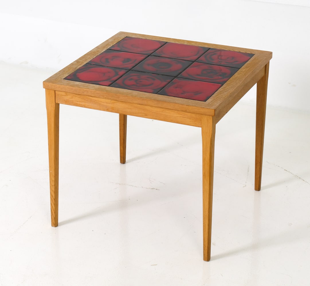 DANISH OAK & CERAMIC TILE SIDE TABLE C. 1970S: Oak frame and legs with black and red abstract ceramic tile set in the top. Denmark, circa 1970s. Dimensions: H 20" x W 21.5" x D 21.5" Condition: Few minor scuffs to wood. Crazing to ceramics. ES2-29