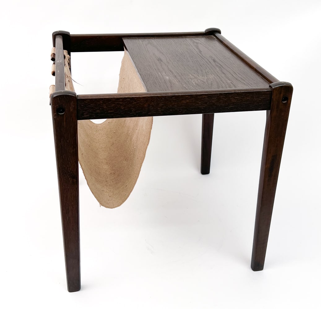 BRDR FURBO DANISH OAK MAGAZINE RACK C. 1960S: Features a fabric sling and stained oak frame. Apparently unmarked. Denmark, circa 1960's. Dimensions: H 18" x W 18" x D 18" Condition: Wear consistent with age and use. Four inch crack to one leg. ES
