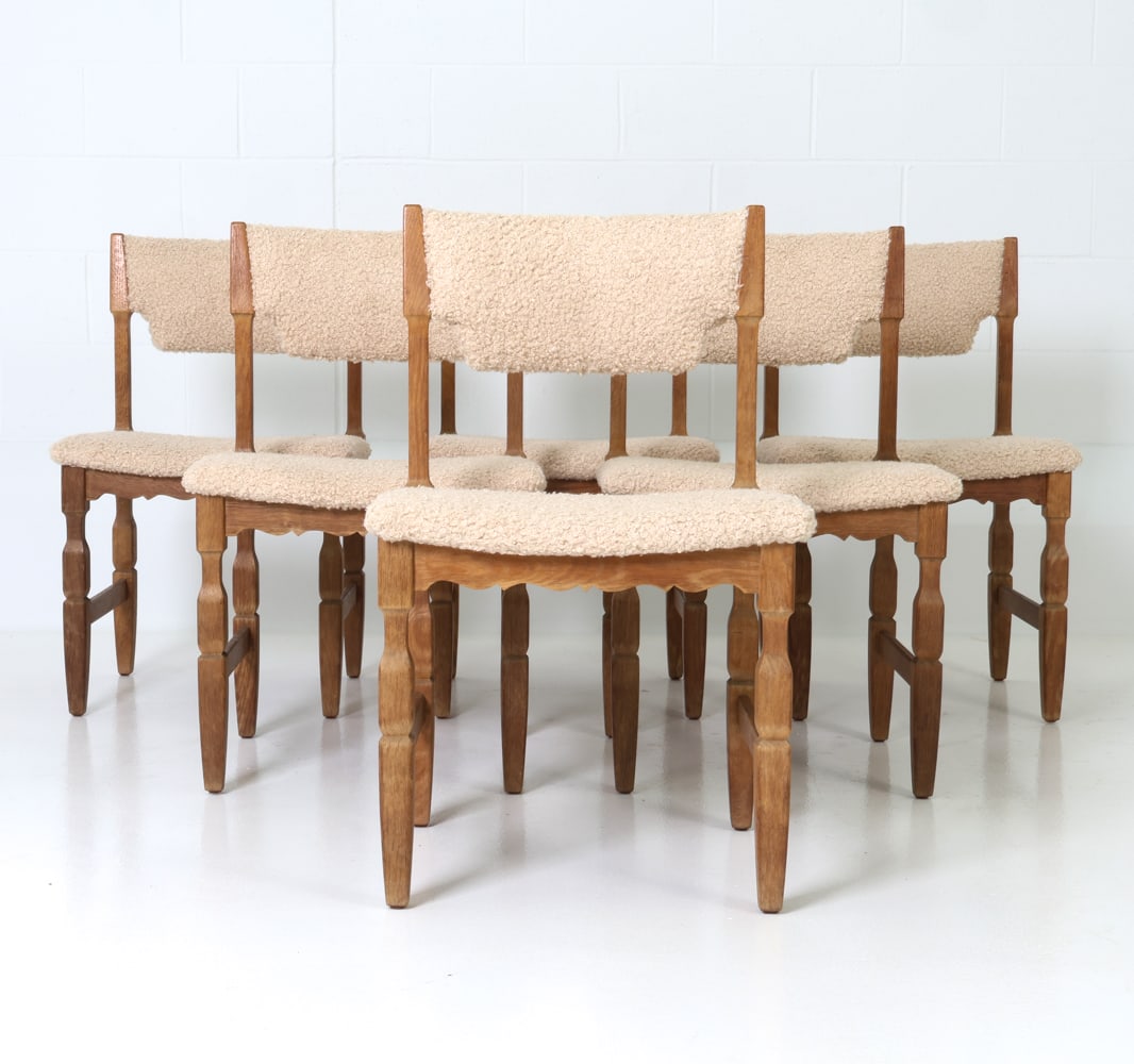 (6) ATTR. HENNING KJAERNULF OAK DINING CHAIRS: Six dining chairs with shearling upholstery and carved oak frame. Denmark, circa 1970's. Dimensions: H 32.25" x W 19.75" x D 19" x SH 18" Condition: Newly upholstered. Minor rubs and scuffs to wood co