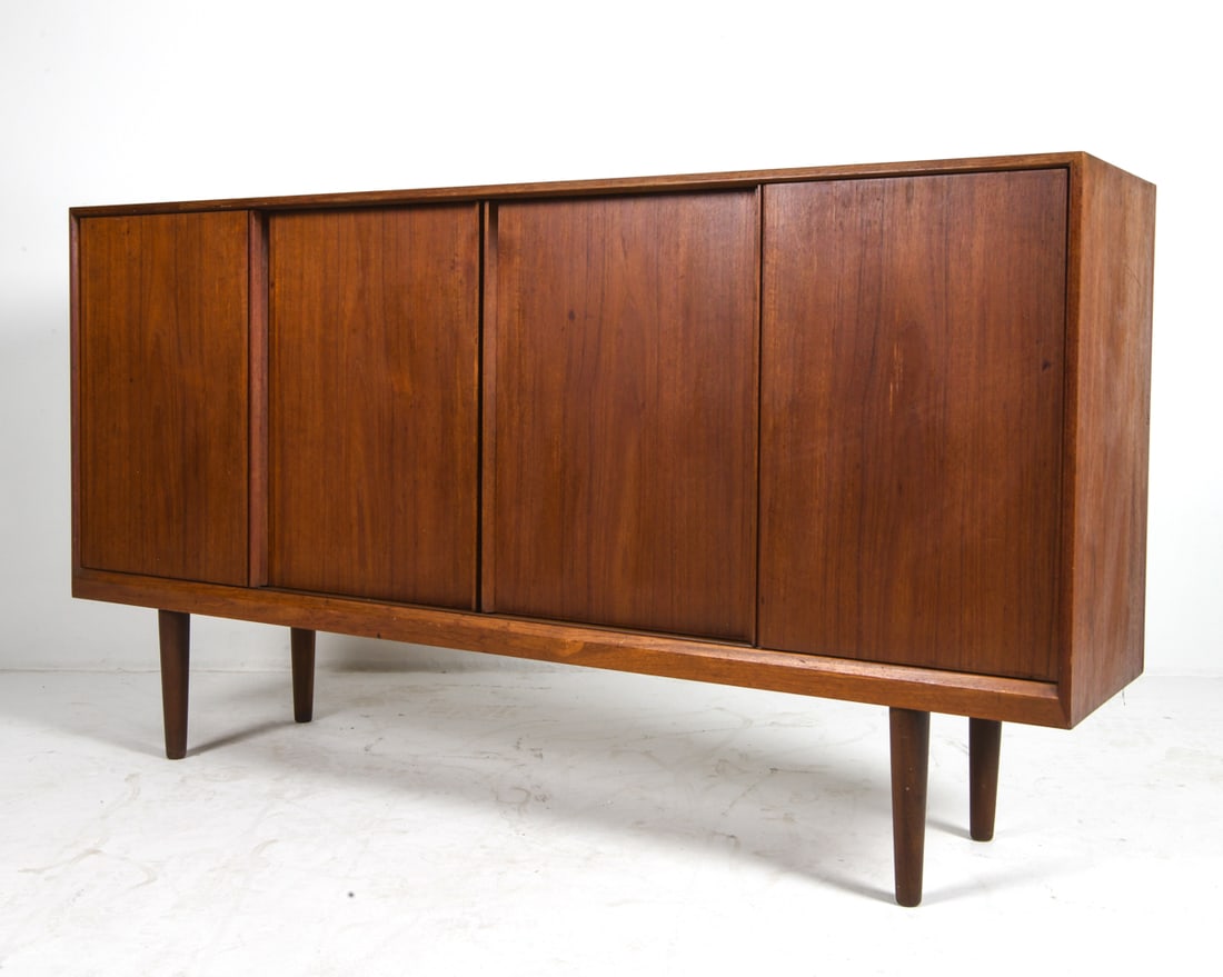 OLHOLM MOBEL DANISH TEAK SIDEBOARD C. 1970S: Stamped on back. Adjustable shelves. Denmark, circa 1970s. Dimensions: H 42.75" x W 78.75" x D 17.5" Condition: Wear consistent with age and use including faint rubs and scuffs, faint water marks to