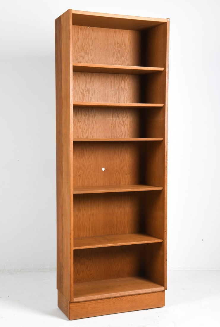 CARLO JENSEN FOR HUNDEVAD DANISH OAK BOOKCASE: Adjustable shelves. Apparently unmarked. Denmark, circa 1970s. Dimensions: H 77" x W 28" x D 12". Condition: Wear consistent with age and use. Hole cut-out into back.