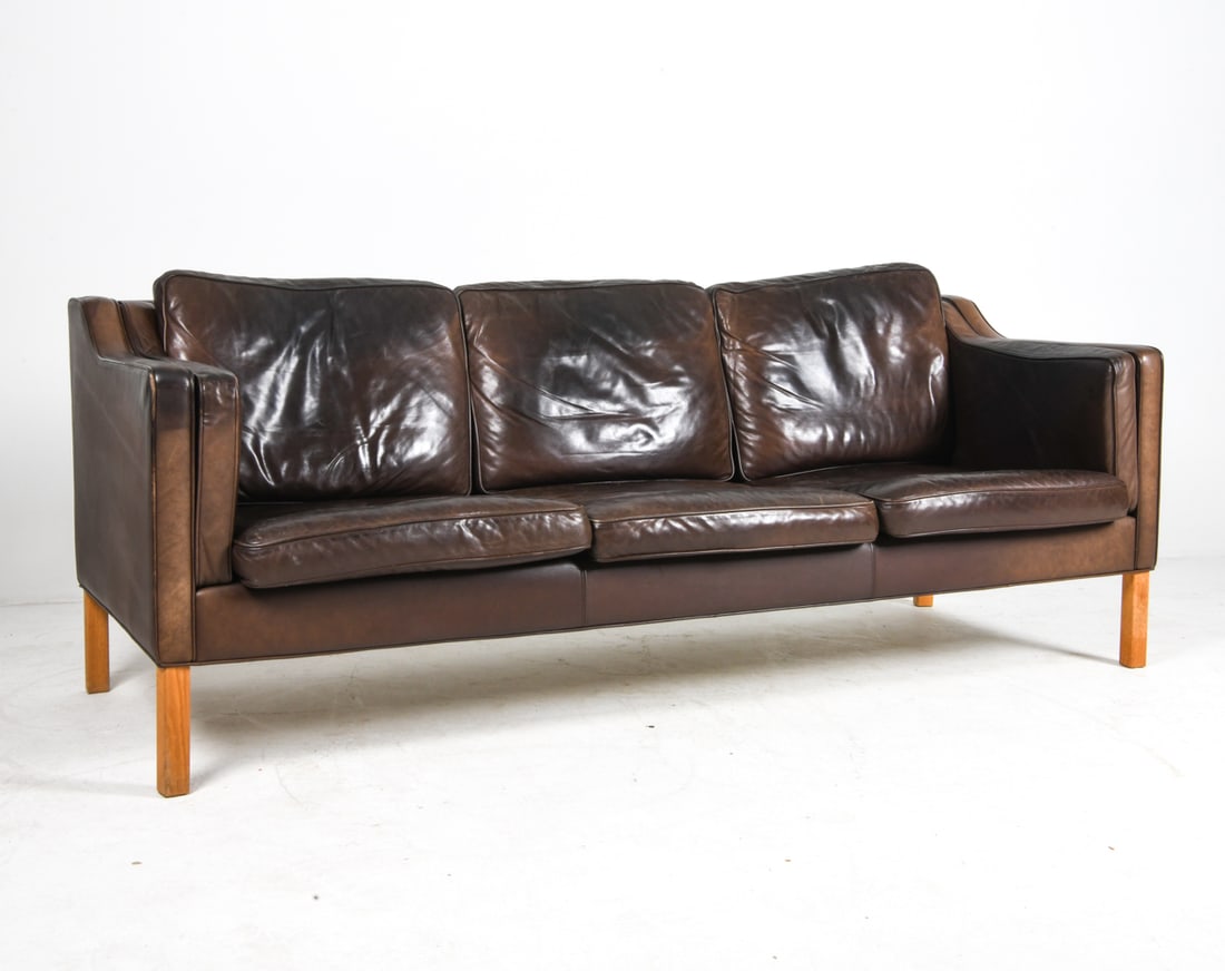 HURUP MOBLER DANISH LEATHER SOFA C. 1970S: Tagged to fabric lining. Brown leather upholstery with beech legs. Denmark, circa 1970s. Dimensions: H 31.5" x W 84.75" x D 32.25" x Sh 16.25". Condition: Wear consistent with age and use including mi