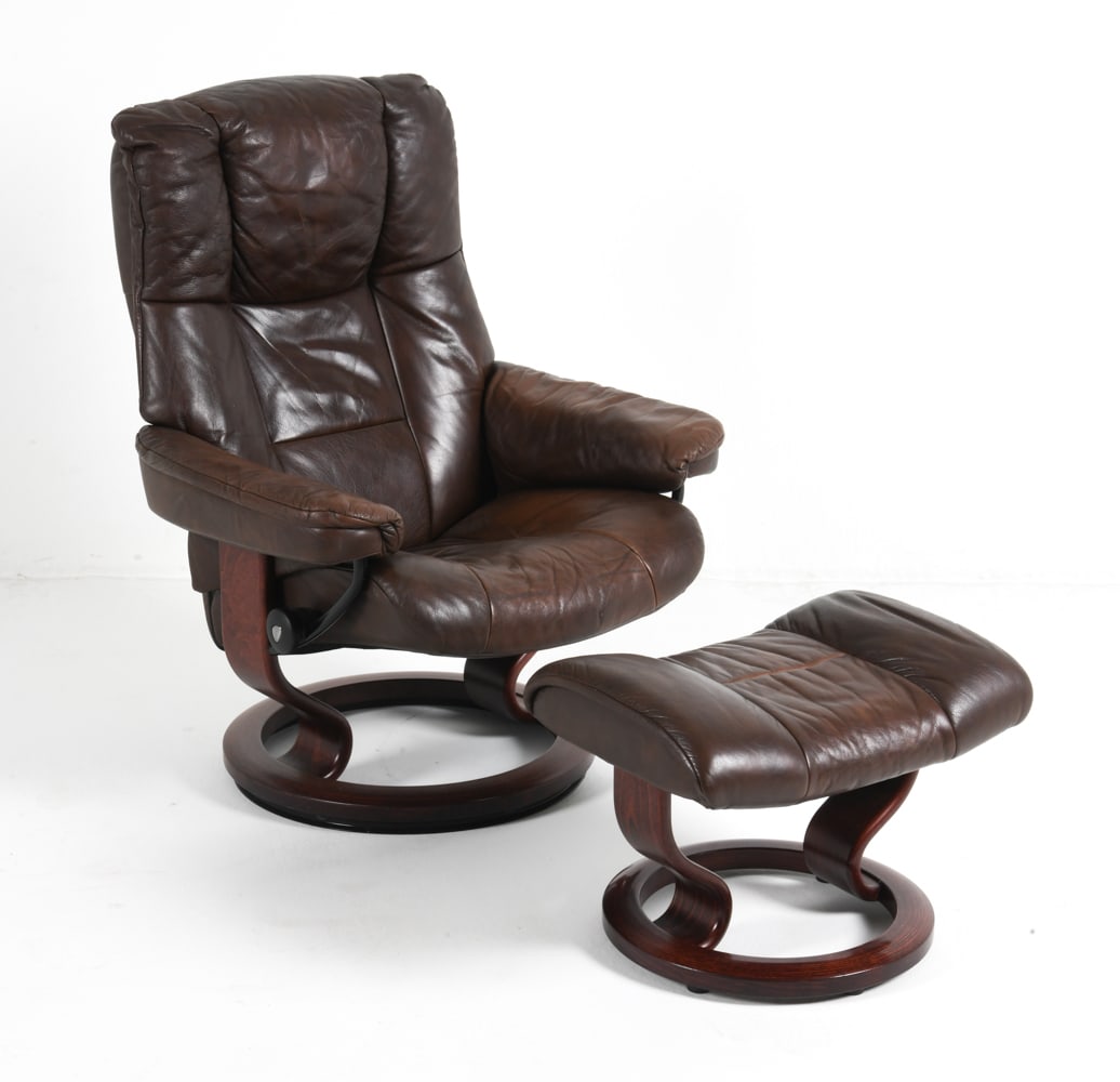 EKORNES STRESSLESS LEATHER LOUNGE CHAIR & OTTOMAN: Beech frame with brown leather upholstery. Branded to reclining adjustment knob. Norway, circa 1970s. Dimensions: H 39" x W 31" x D 28" x SH 18". Ottoman H 16" x W 19? x D 16?. Condition: Wear
