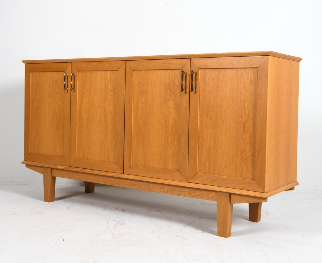 DANISH OAK SIDEBOARD C. 1970S: Adjustable shelves. Brass cabinet door pulls. Denmark, circa 1970s. Dimensions: H 36" x W 68.5" x D 18.25". Condition: Wear consistent with age and use including minor dings and rubs.