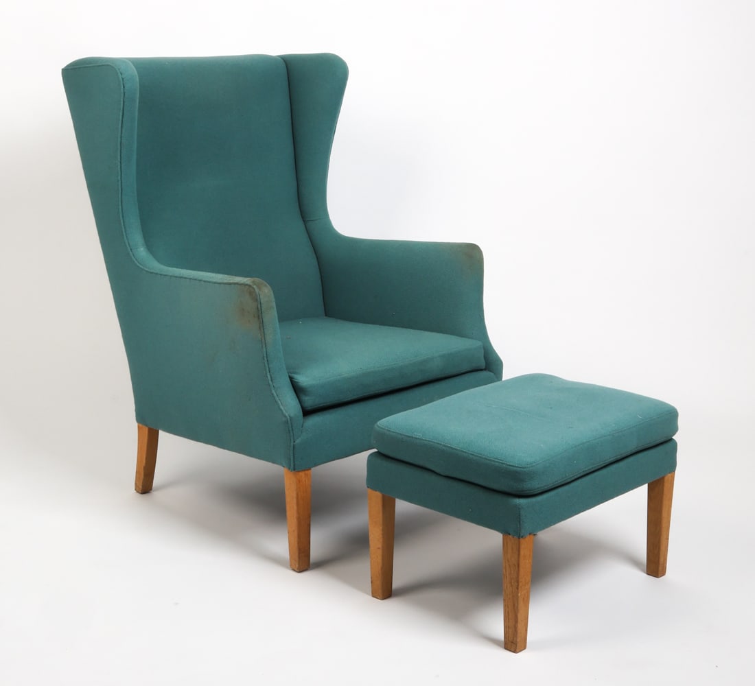 HENNINGSEN STYLE DANISH WINGBACK CHAIR & OTTOMAN: Wingback lounge chair in blue upholstery with matching ottoman. Beech legs. Denmark, circa 1960s. Dimensions: H 40.5" x W 27" x D 31" x Sh 15.25". Ottoman H 14" x W 20" x D 15". Condition: Wear