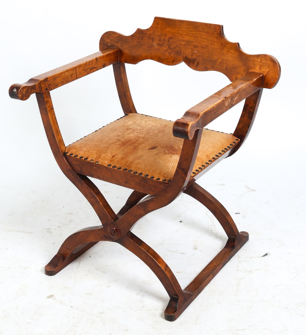 SAVONAROLA STYLE DANISH WALNUT ARMCHAIR: Walnut frame with leather seat. Denmark. Dimensions: H 31.75" x W 28" x D 23" x Sh 17.75". Condition: Wear consistent with age and use including dings and scratches to wood and leather. Fading and