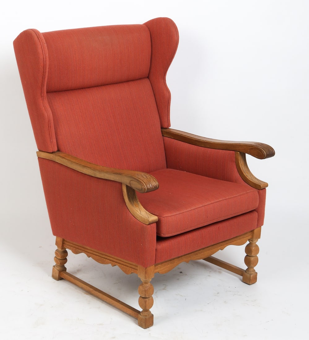 KJAERNULF STYLE DANISH WINGBACK LOUNGE CHAIR 1970S: Oak wingback lounge chair with red colored upholstery. Carved decoration to frame. Denmark, circa 1970s. Dimensions: H 41.25" x W 27.25" x D 31" x Sh 17". Condition: Wear consistent with age and use,