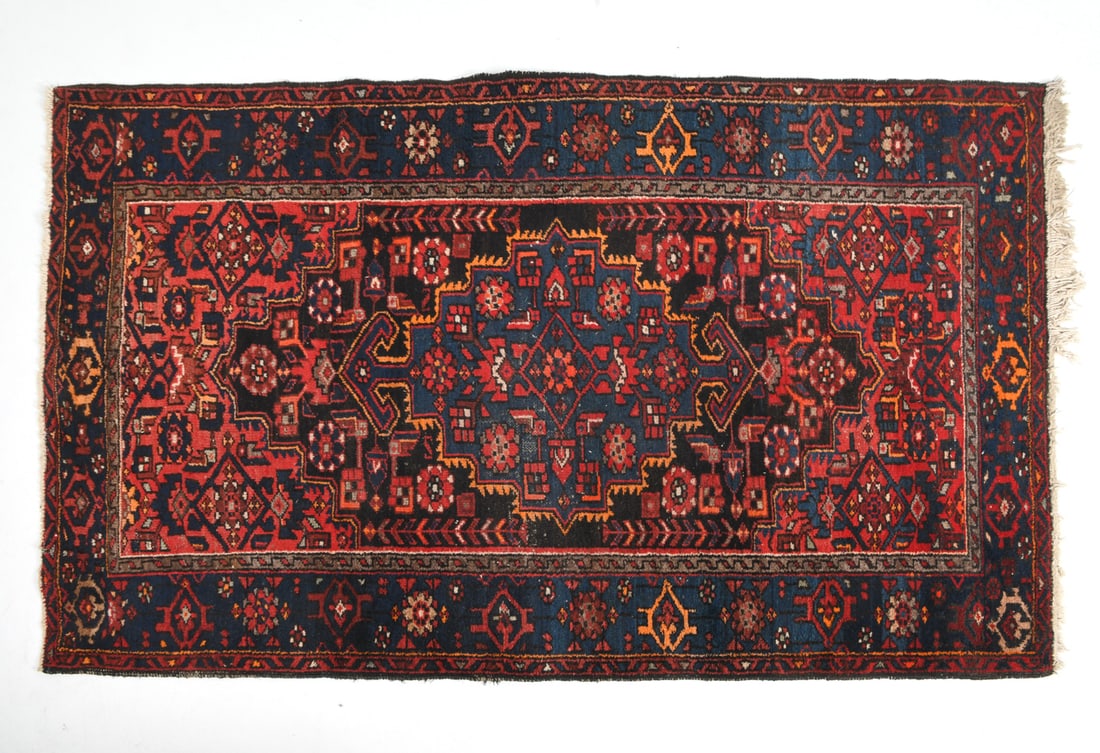 ORIENTAL RUG: Hand-knotted red oriental rug with geometric design. 20th century. Dimensions: L 86" x W 54.5". Condition: Losses to border, minor fading, losses to pile in center.