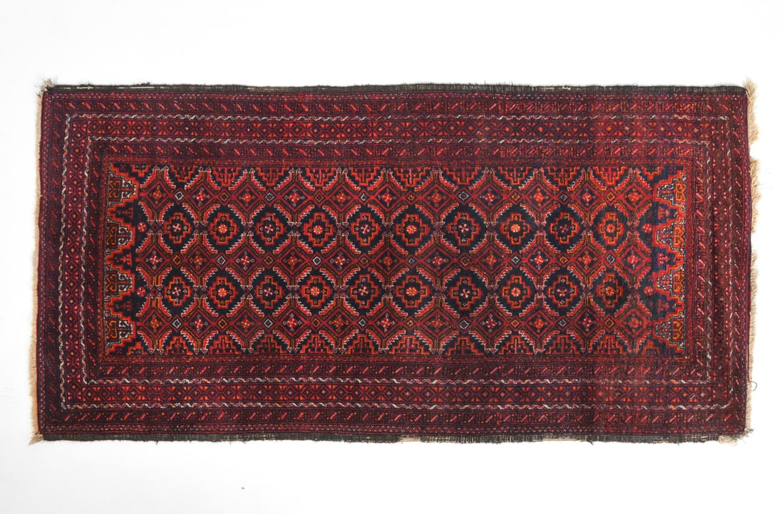 ORIENTAL RUG: Red hand-knotted oriental rug with geometric design. 20th century. Dimensions: L 68.5" x W 34.5". Condition: Loss to border and fringe. Overall presents well.